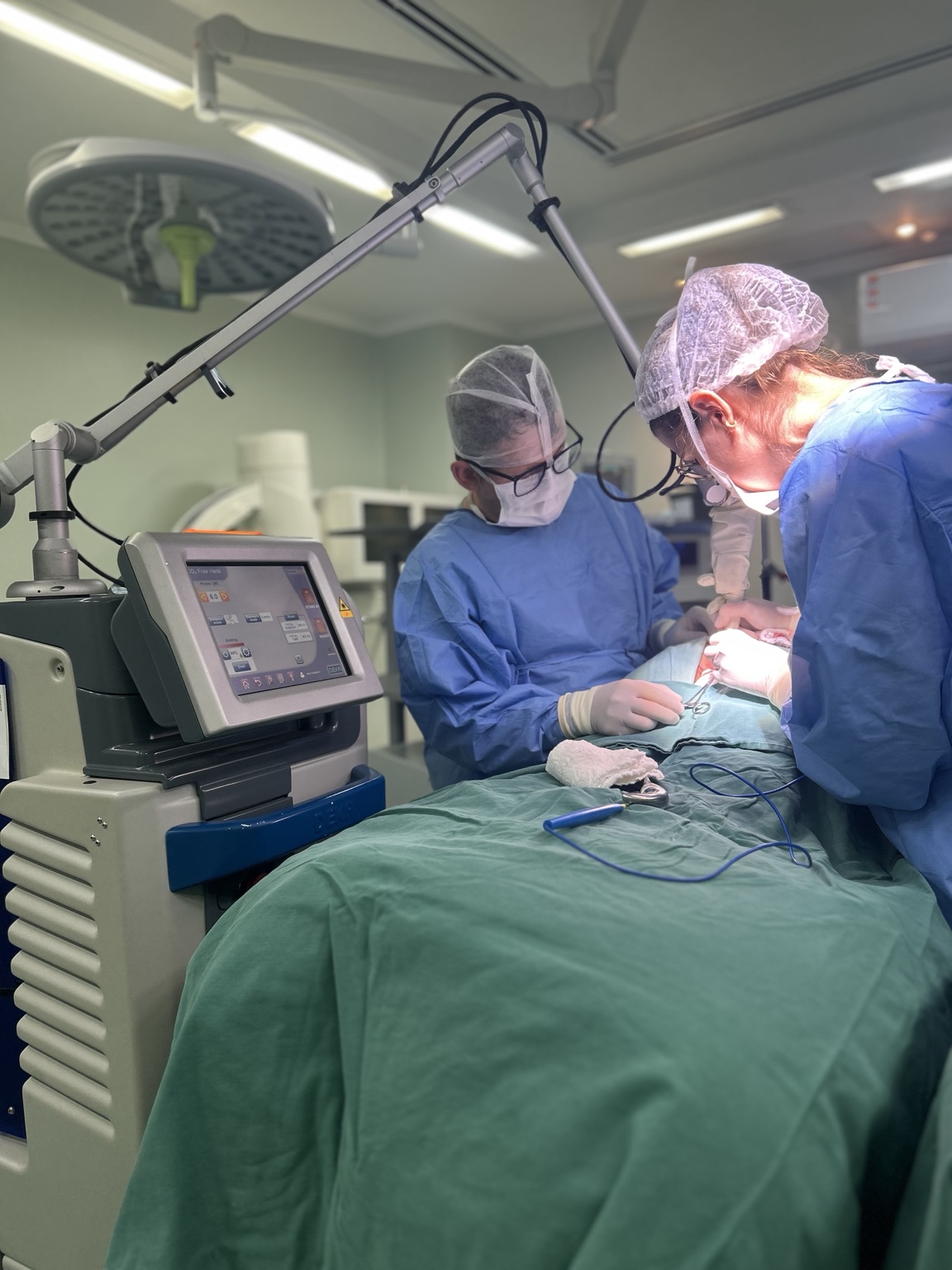 Equipamento a laser preparado ao lado da equipe médica