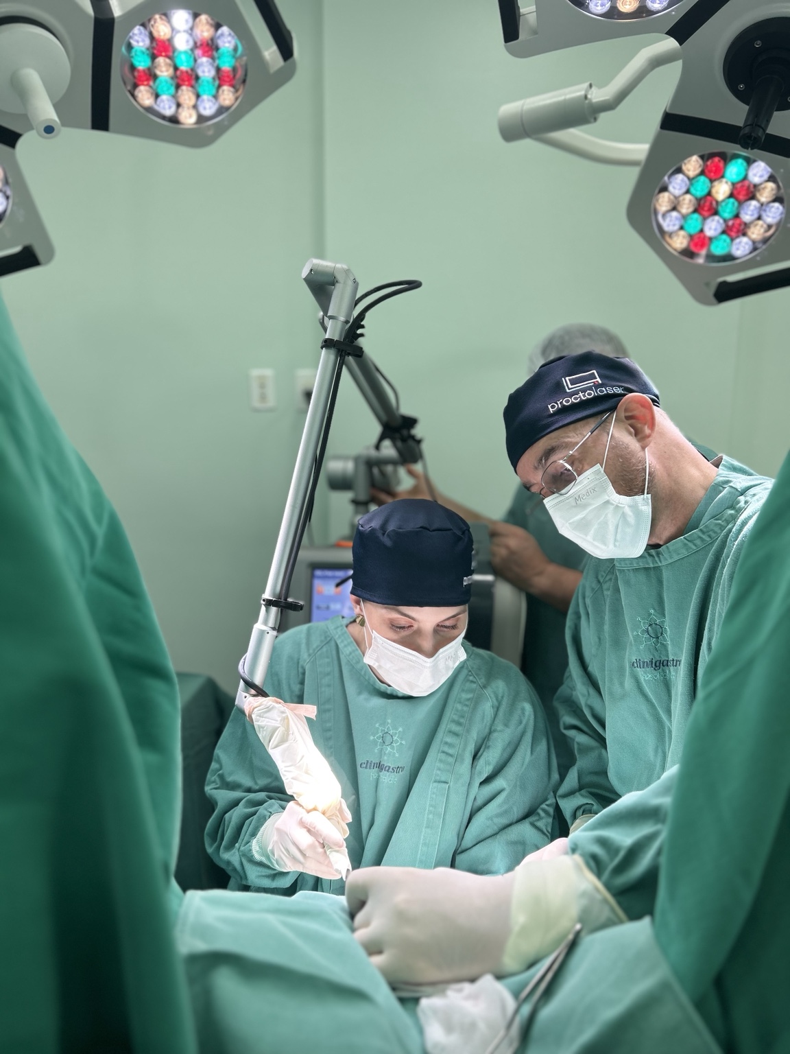 Profissionais em centro cirúrgico utilizando equipamento médico